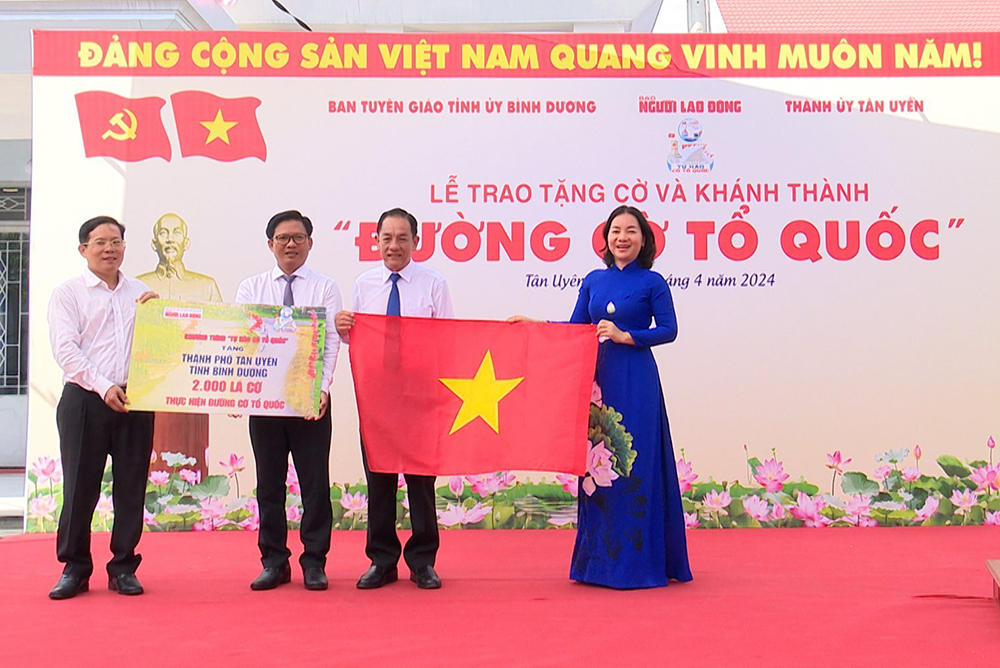 Đại diện Báo Người Lao động trao tặng 2.000 lá cờ cho TP. Tân Uyên và xã Thạnh Hội.